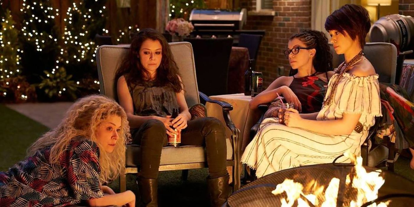 Tatiana Maslany as four different clone versions sitting outside by a fire in Orphan Black.
