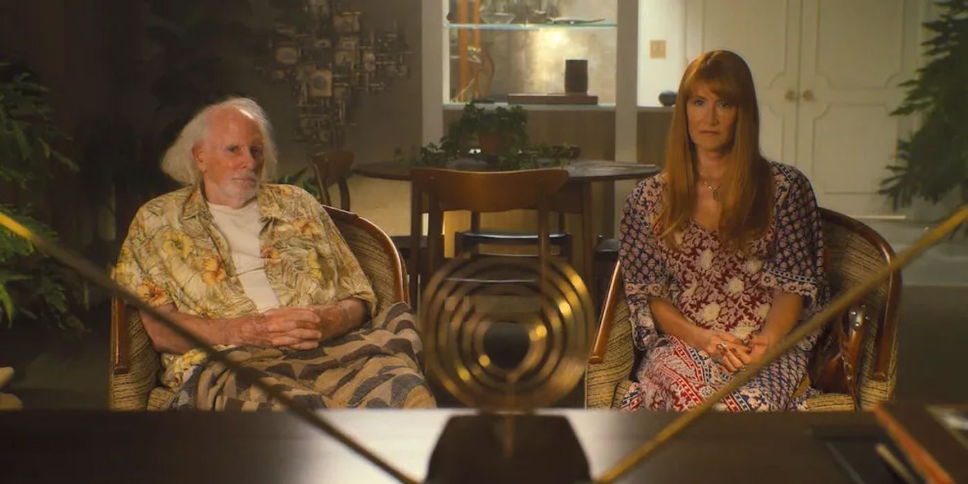 Bruce Dern and Laura Dern watch TV together in a scene from Palm Royale.