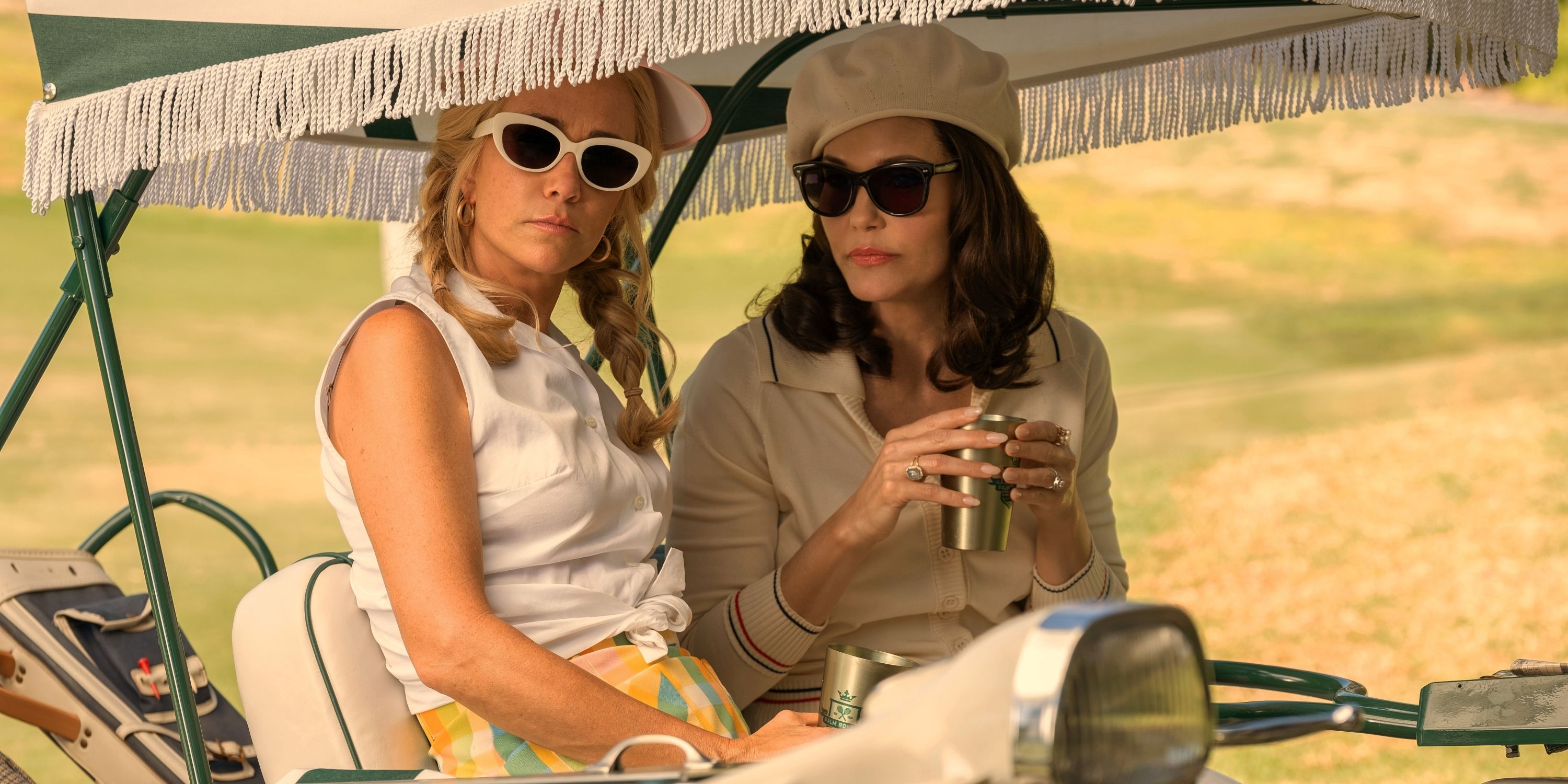 Leslie Bibb as Dinah Donahue sitting in a golf cart with Kristen Wiig in Episode 5 of Season 1 of Palm Royale