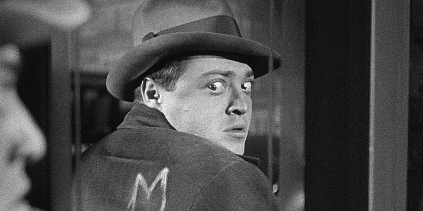 Peter Lorre with an M on his back, looking at a mirror in 'M' (1931)