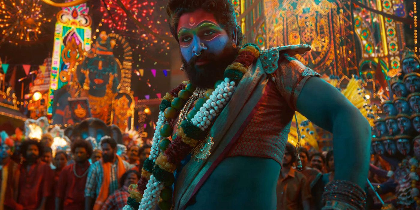 Allu Arjun in a crowd wearing elaborate makeup and beads in Pushpa 2 The Rule