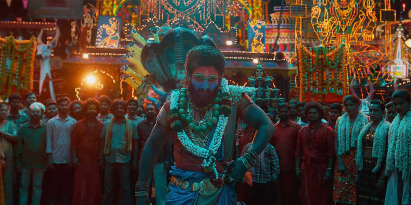 Allu Arjun in a crowd wearing elaborate makeup and beads in Pushpa 2 The Rule