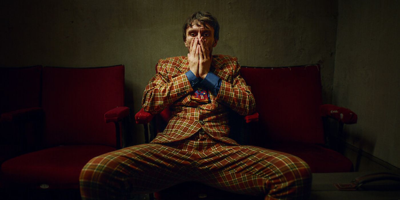 Richard Gadd as Donny sitting on a couch in a suit in 'Baby Reindeer'