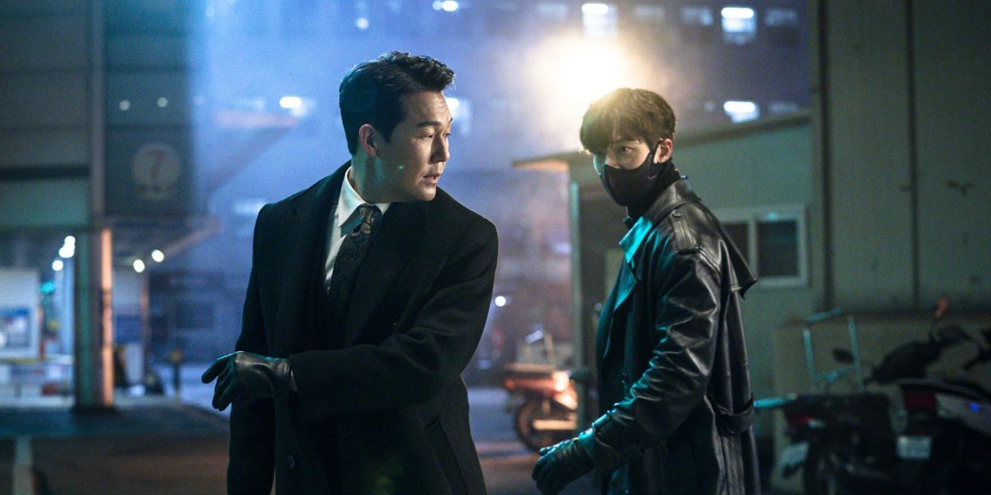 A man in a business suit tries to avoid the grasp of a man wearing a face mask in Rugal.