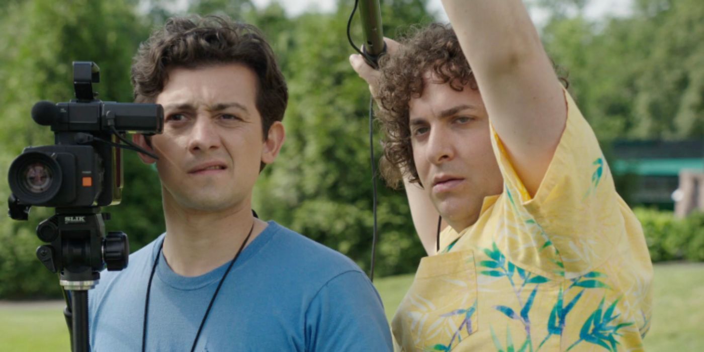 Craig Roberts and Oliver Cooper as David and Wheeler filming with a video camera and wearing a hawaiin shirt in &lsquo;Red Oaks&rsquo;