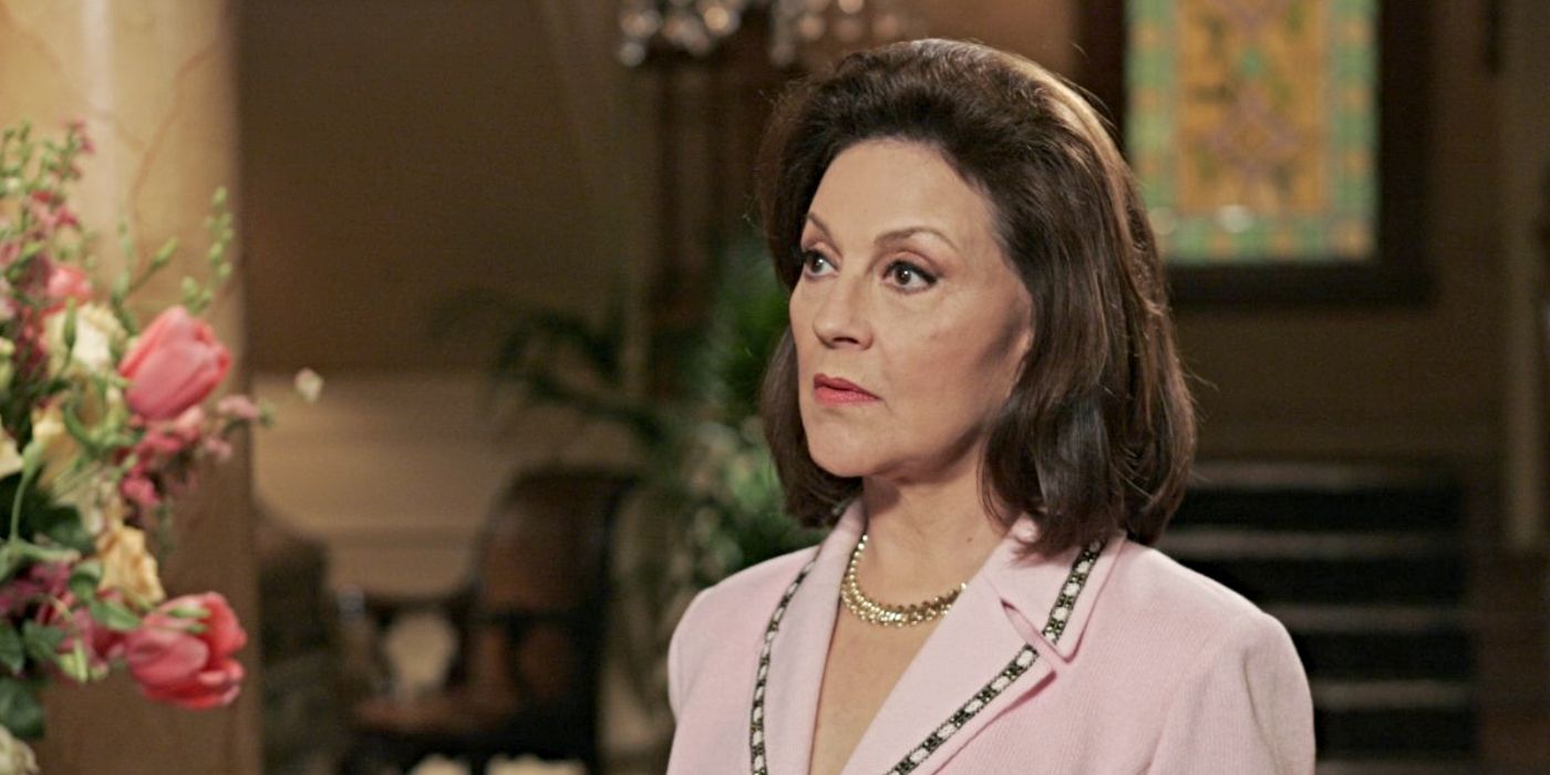 Kelly Bishop as Emily Gilmore, wearing a pink jacket and looking surprised in her house on Gilmore Girls