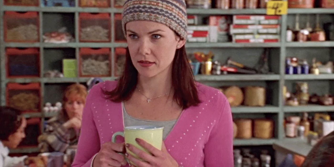 Lorelai Gilmore, wearing a hat and holding a coffee cup in Luke's Diner in the pilot episode of Gilmore Girls