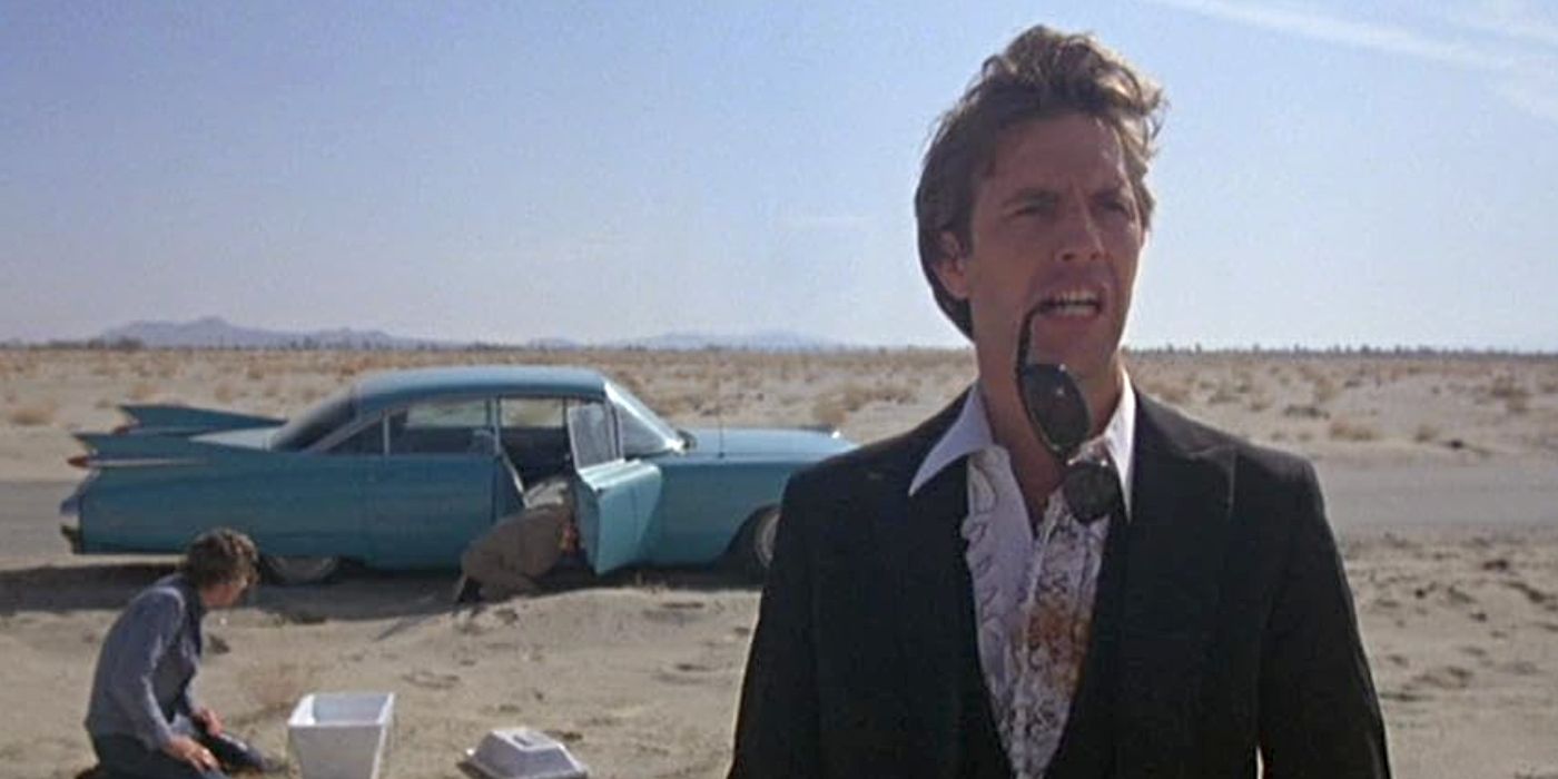 Kevin Costner as Gardner Barnes, standing by a car in the desert, in 'Fandango'