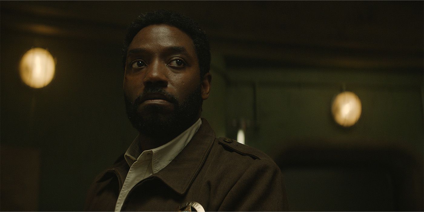 David Oyelowo looks fearfully to his left in a darkened silo corridor