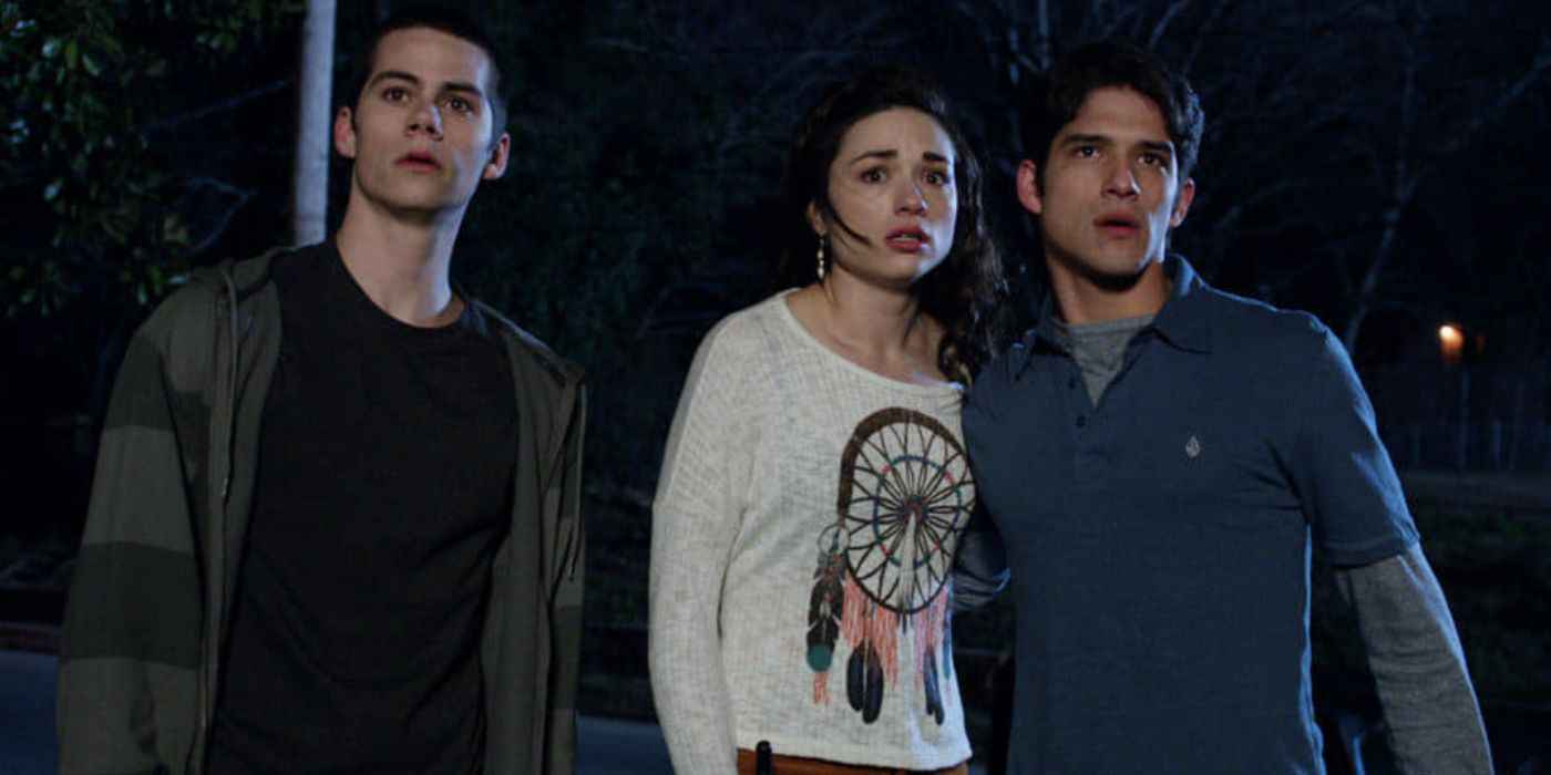 Dylan O'Brien, Crystal Reed, and Tyler Posey looking frightened at something off camera in Teen Wolf