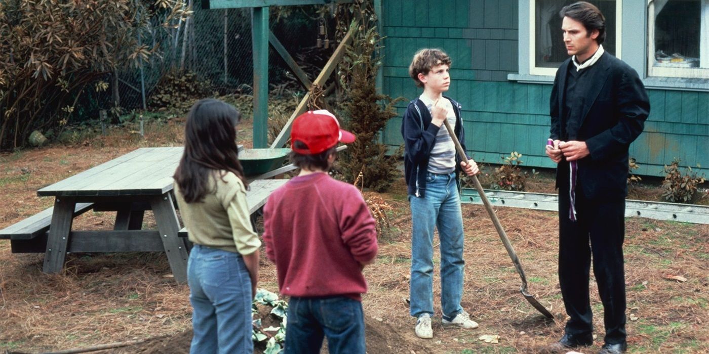 Phil Pitkin talking to a group of children in a yard in Testament (1983)