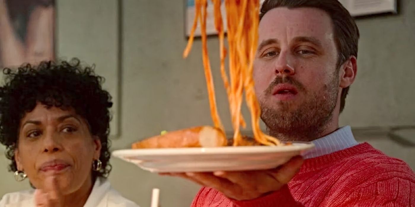 Chris Witaske como Pete sostiene un plato de espaguetis y mira fijamente a Tina (Liza Colon-Zayas) en “El oso”.