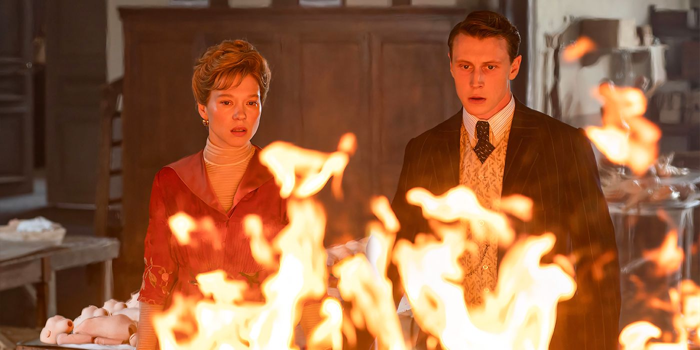 Léa Seydoux and George MacKay stare at flames in The Beast. 