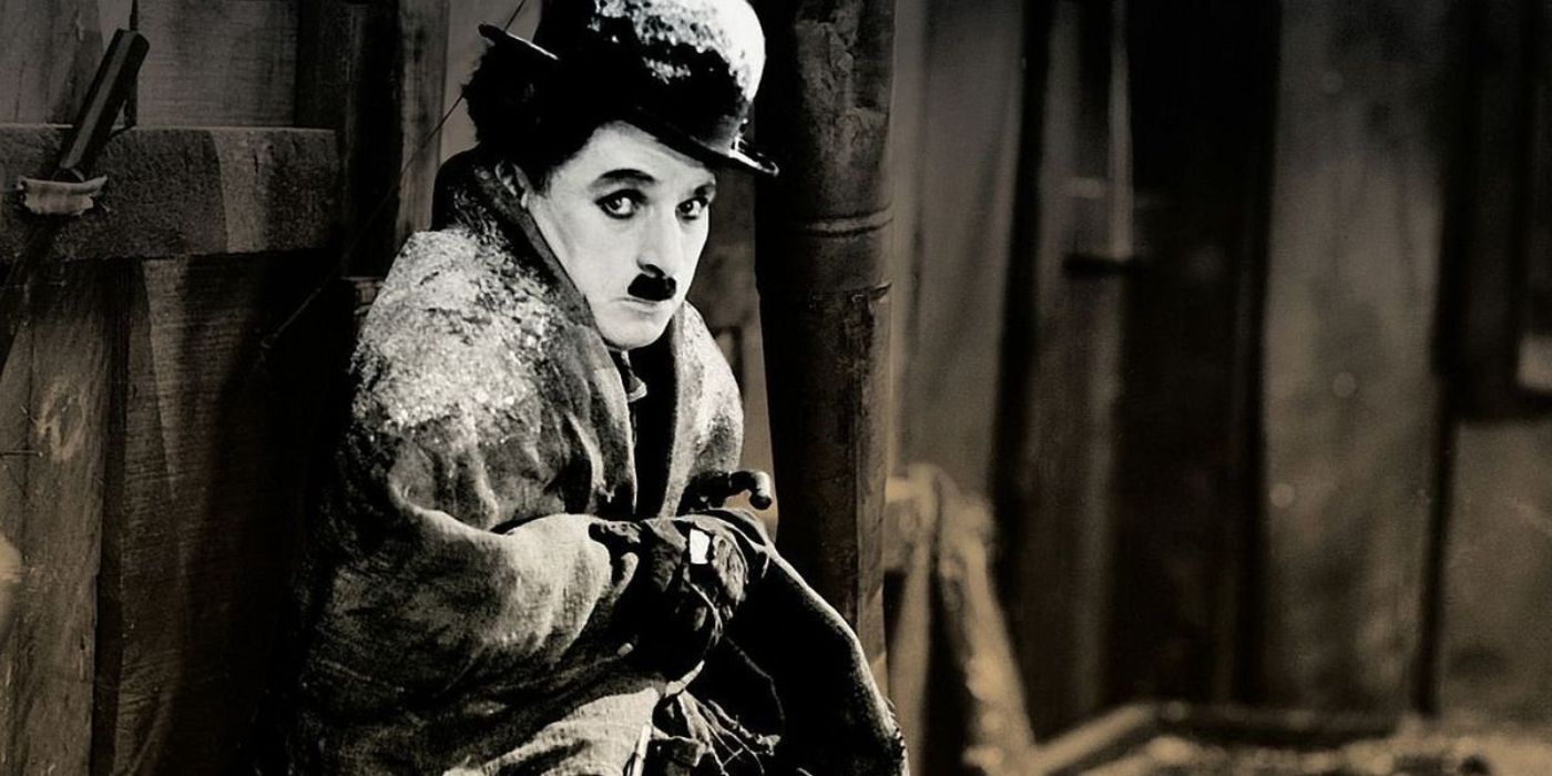 Sitting huddled in the freezing cold, the Little Tramp (Charlie Chaplin) wears his bowler hat as he sits against a shack in 'The Gold Rush' (1925)