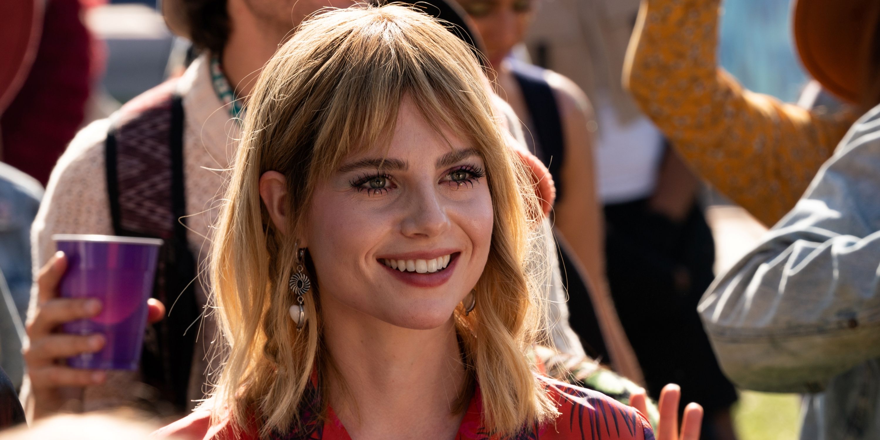 Lucy Boynton as Harriet in closeup while smiling in The Greatest Hits