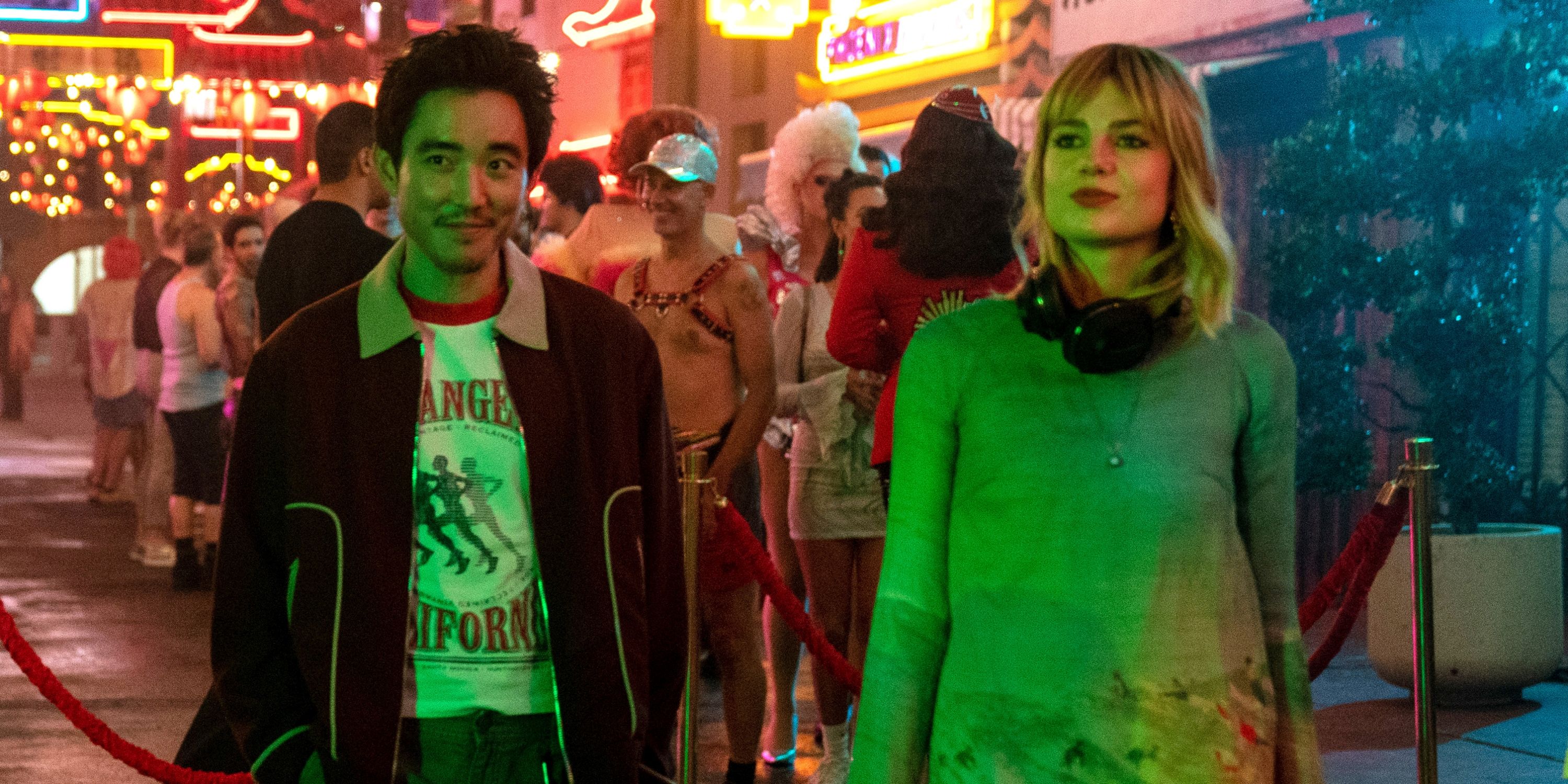 Lucy Boynton as Harriet with headphones on standing next to Justin H. Min as David in The Greatest Hits