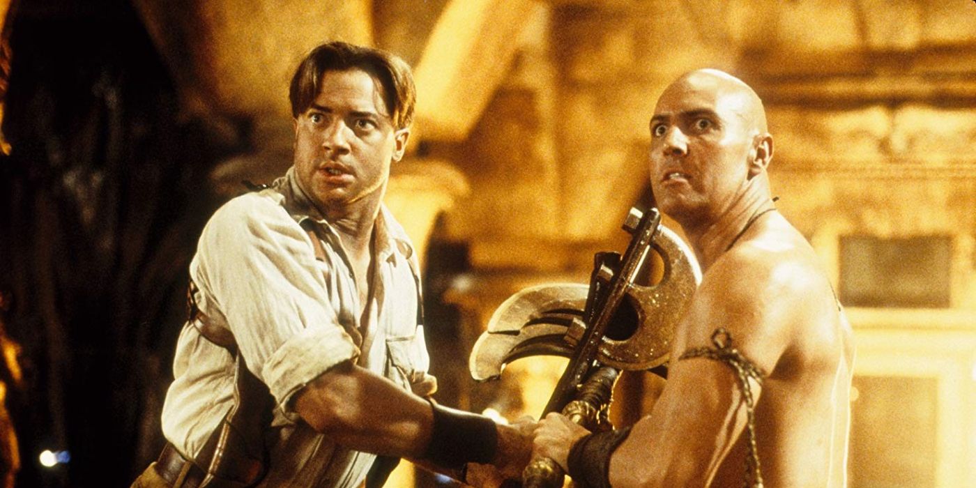 Rick O'Connell (Brendan Fraser) and Imhotep (Arnold Vosloo) staring intensely at something offscreen to the left while fighting one another in The Mummy