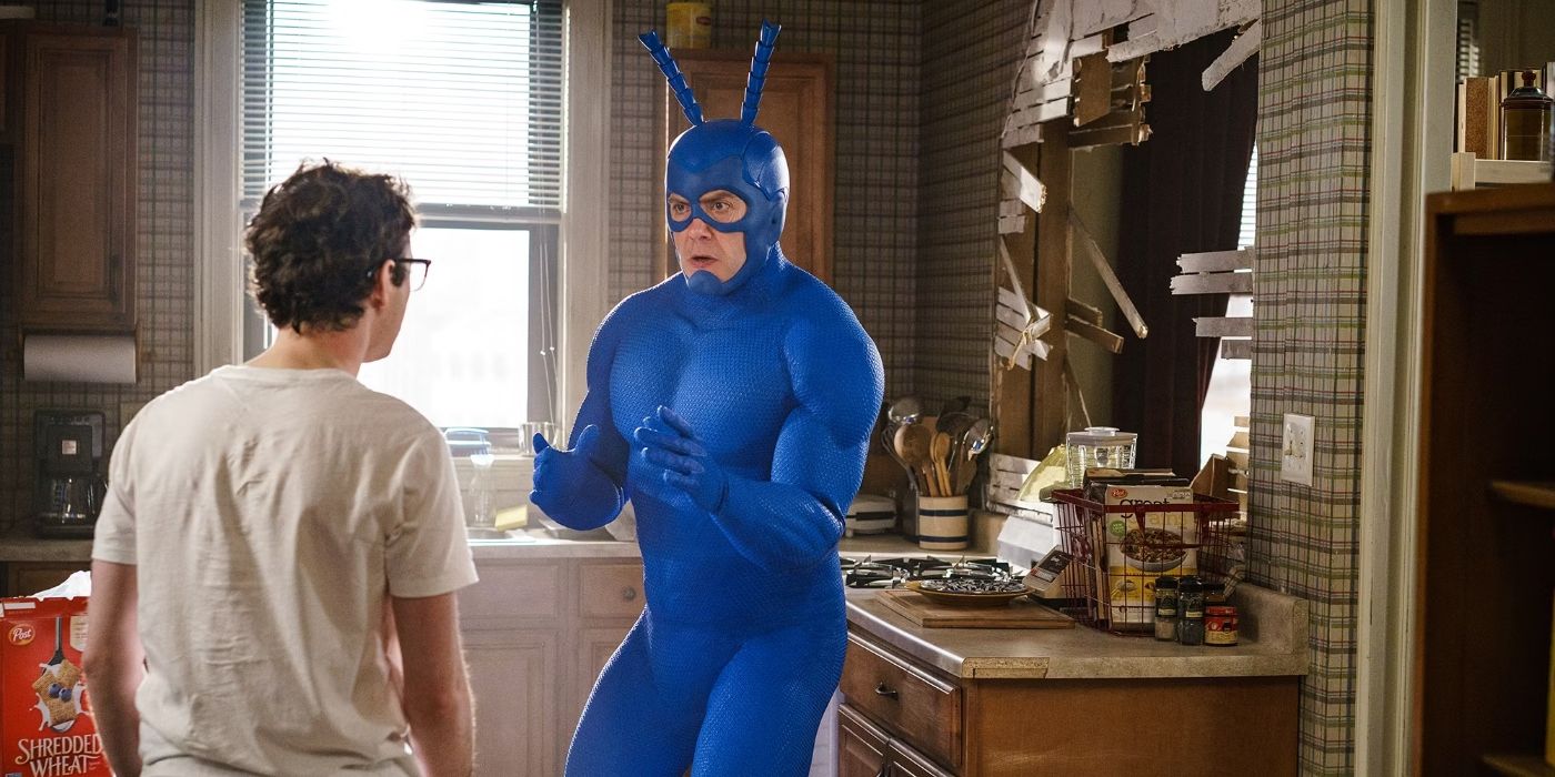 Peter Serafinowicz in a blue tick outfit talking to someone in a kitchen in The Tick Season 2.