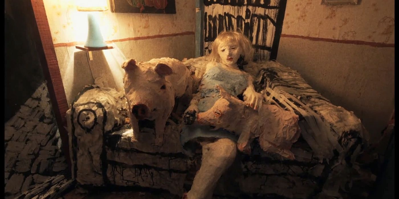 A young girl lying on a couch with two pigs in The Wolf House