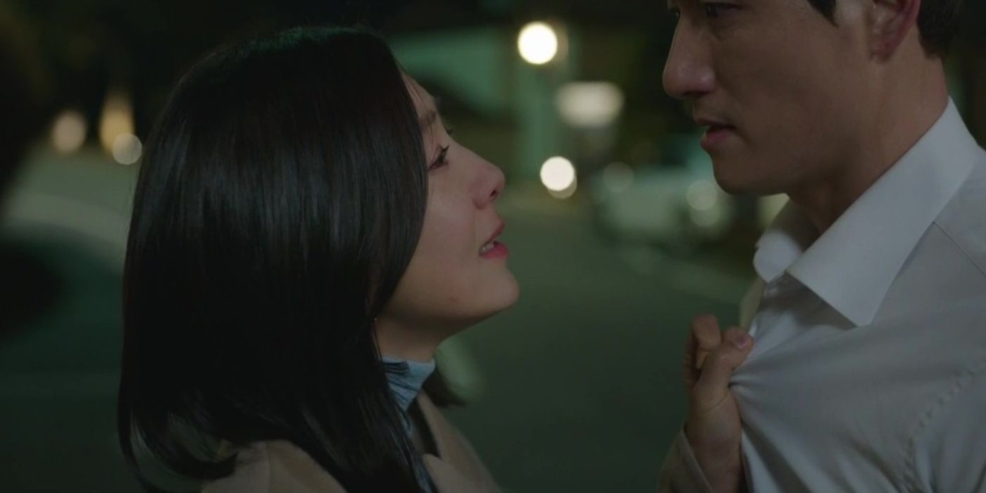 A woman grabs a man&rsquo;s shirt on the chest and speaks to him in a street at night in The World of the Married.