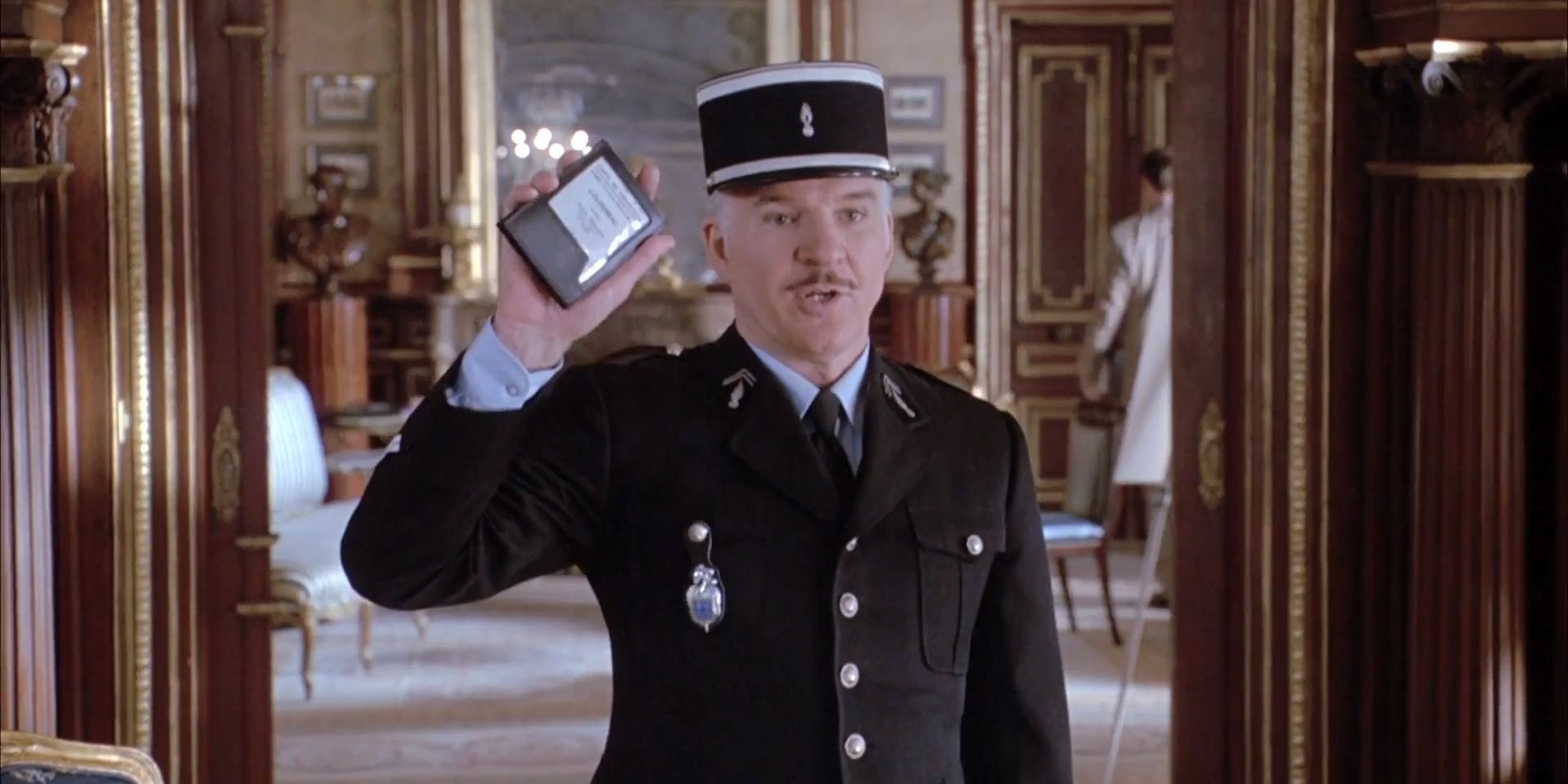 Steve Martin as inspector Jacques Clouseau wearing a formal uniform and holding up a notepad in The Pink Panther (2006)