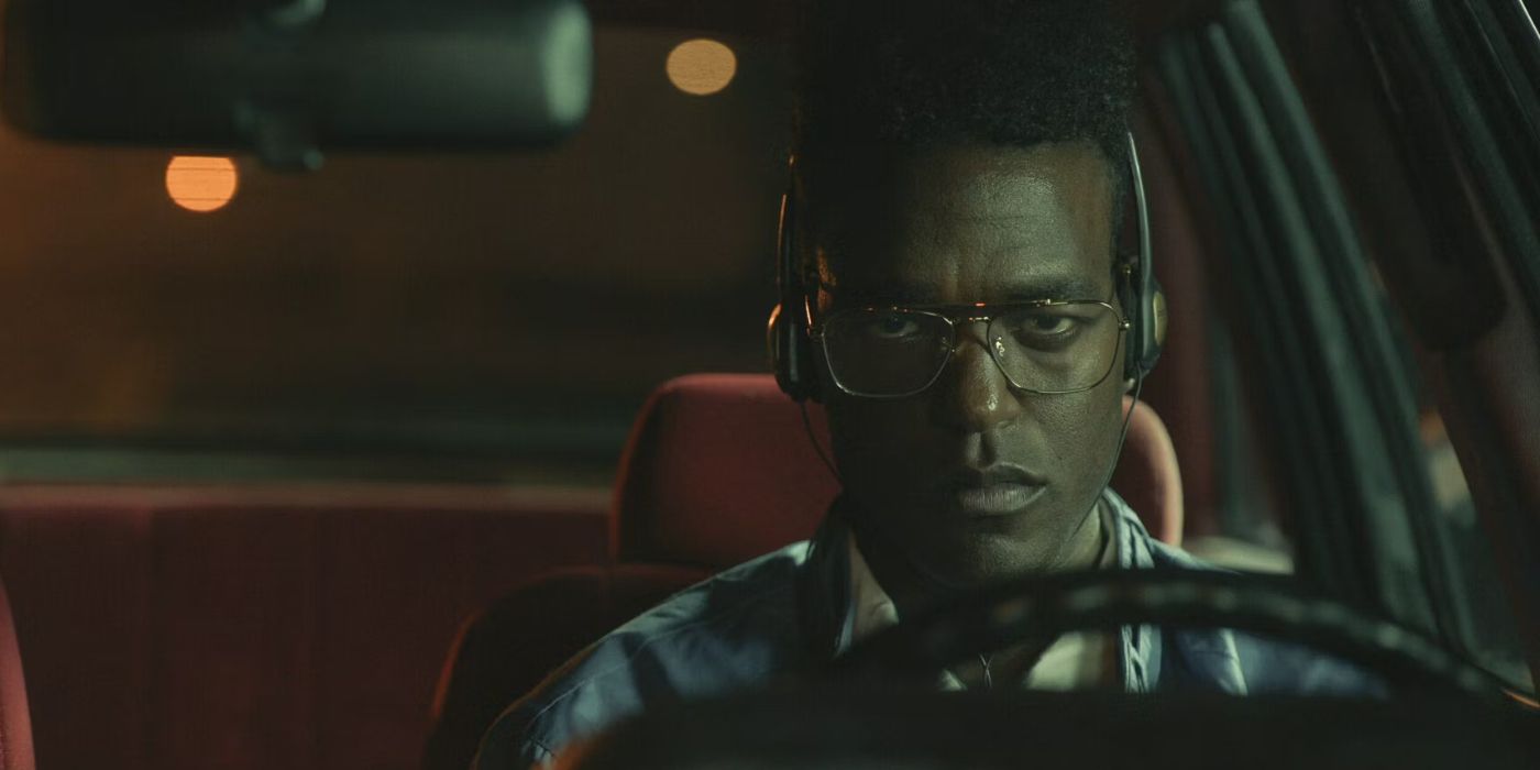 Luke James wearing headphones sits in a car staring ahead in 'Them: The Scare