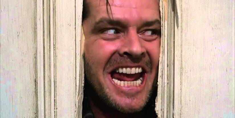Jack Torrance pushing his face through a broken door in The Shining.