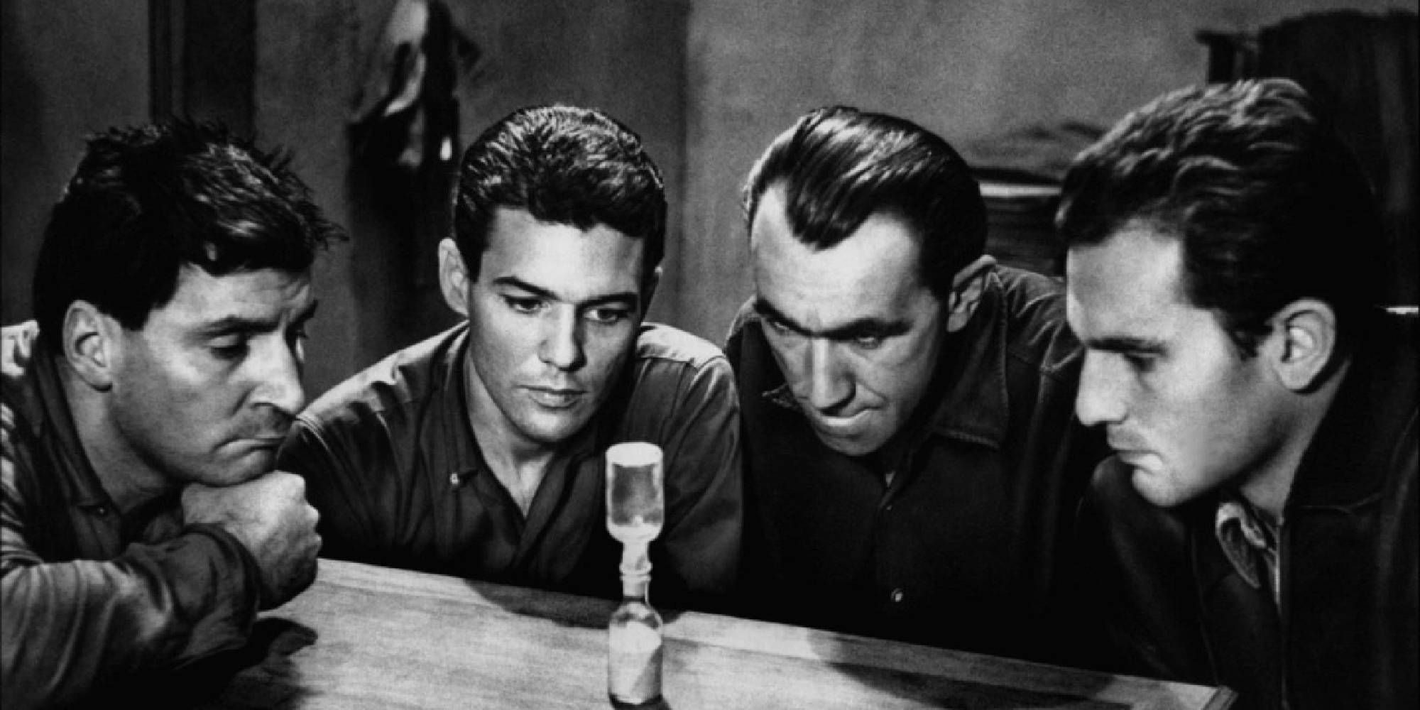 Three men in Le Trou looking at an hourglass.
