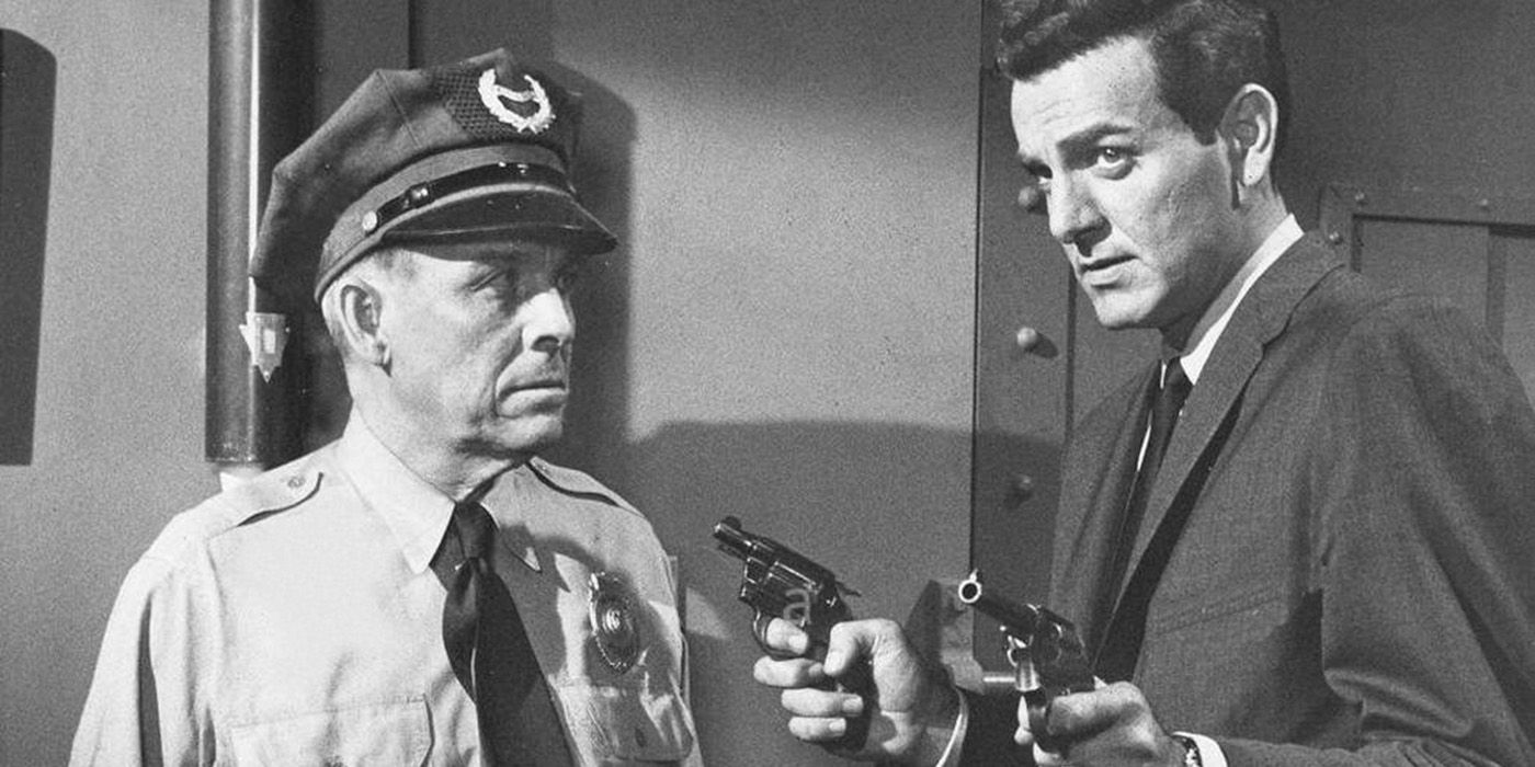 A cop and a man in a suit standing together while the man in a suit holds two guns in Tightrope