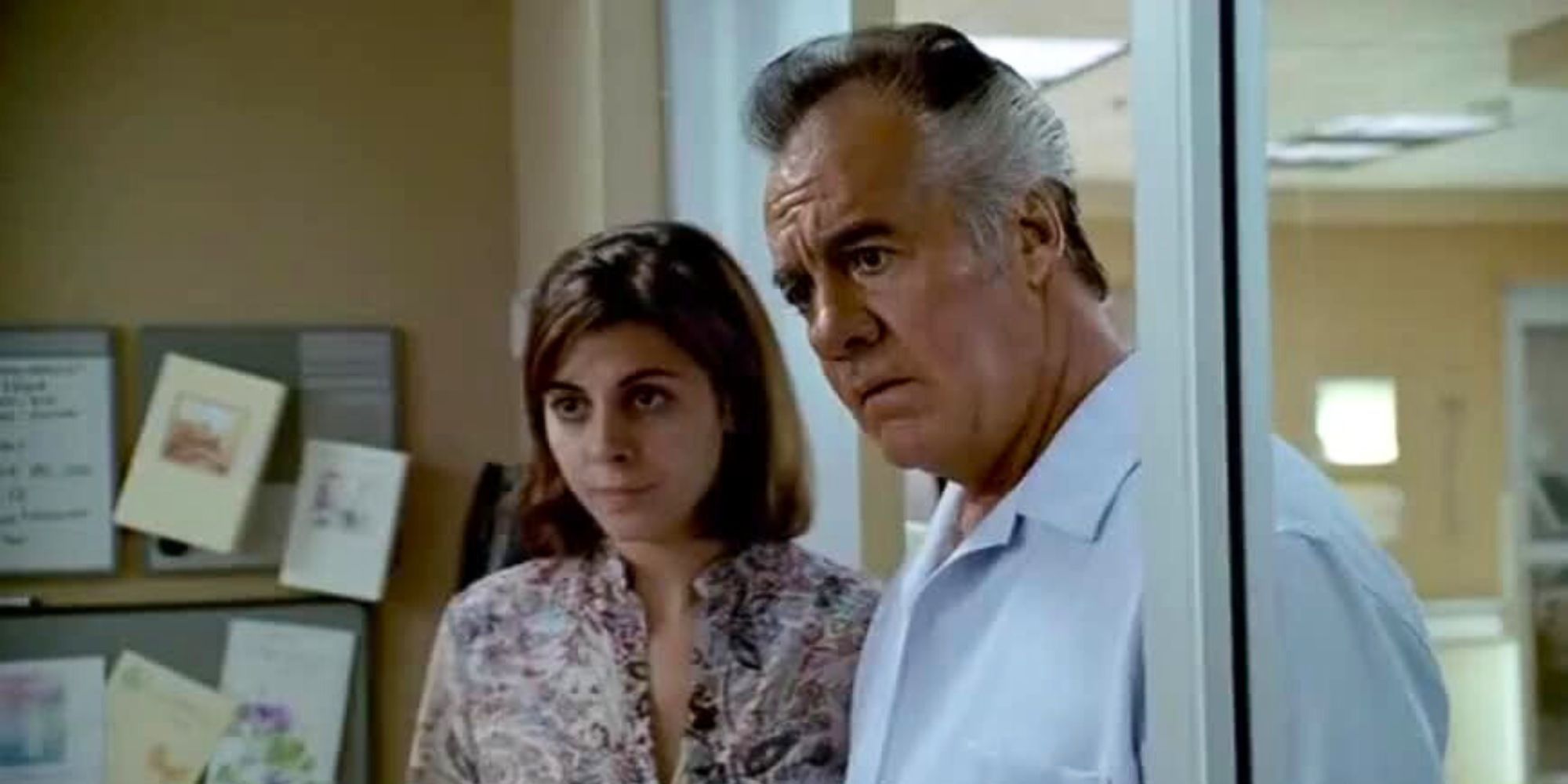 Tony Sirico as Paulie Walnuts standing with Jamie Lynn-Sigler as Meadow Soprano in a doorway in The Sopranos