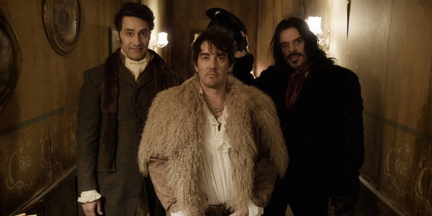 Taika Waititi, Jonathan Brugh, and Jermaine Clement standing together in a hallway in What We Do in the Shadows