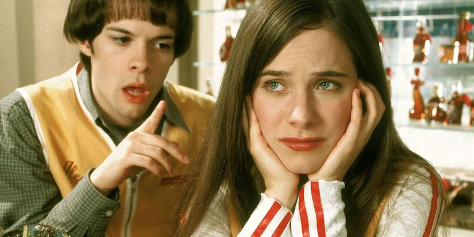 A young person talks to another who is resting their head in their hands, looking perplexed in Wonderfalls.