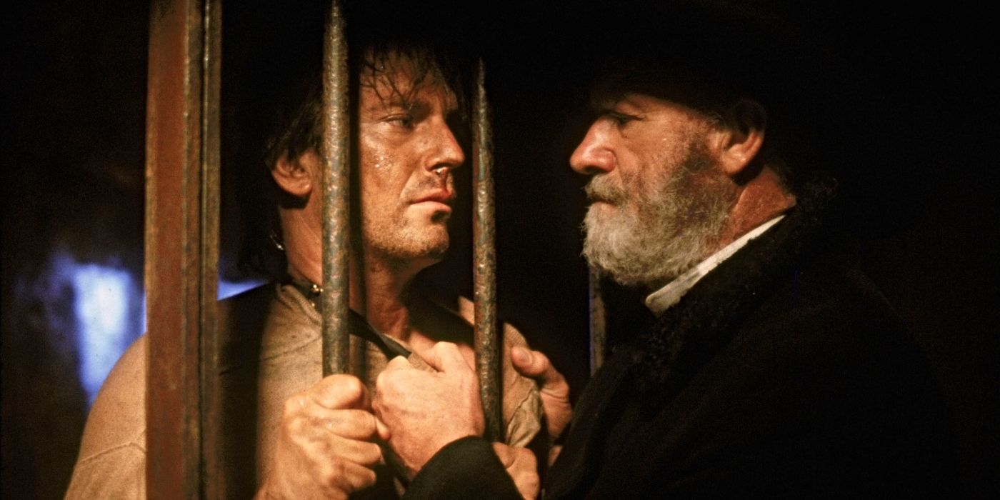 Gene Hackman as Nicholas Earp, holding Kevin Costner as Wyatt Earp by the collar through jail cell bars in &lsquo;Wyatt Earp&rsquo; (1994)