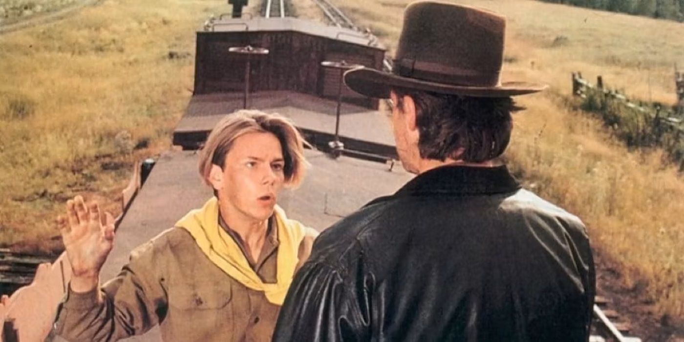 River Phoenix as young Indiana Jones talking to man with his back to the screen in The Last Crusade