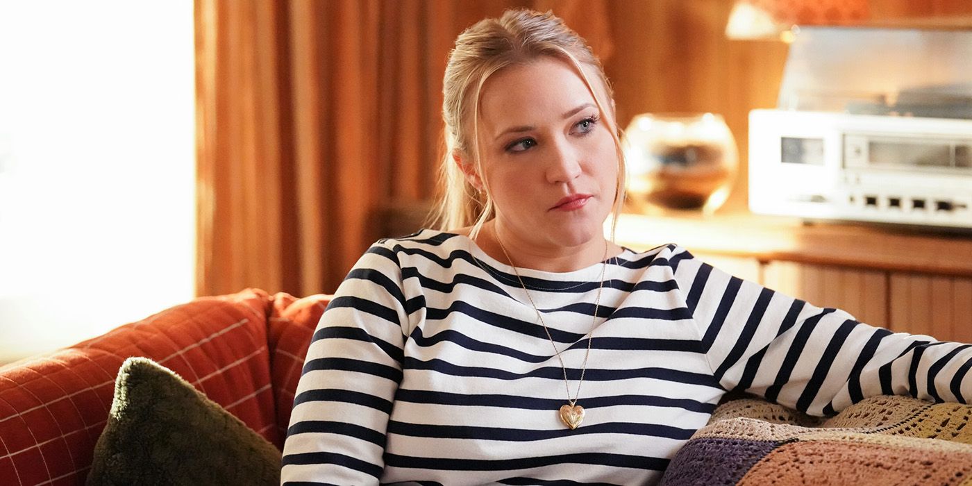 Emily Osment as Mandy sitting on a Couch in a striped shirt in Young Sheldon