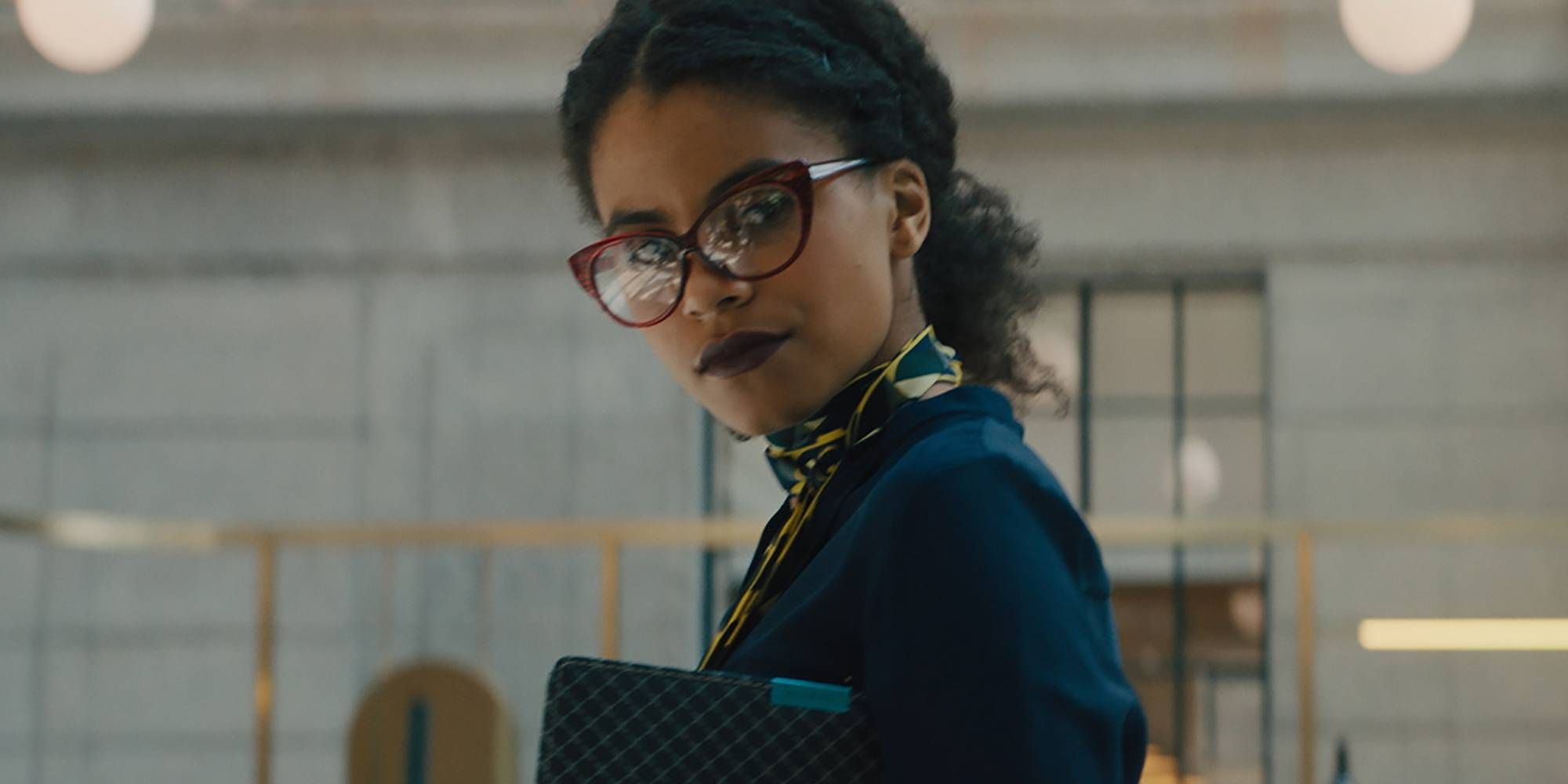 Zazie Beetz wearing red eyeglasses in Dead Pigs and looking at someone off-camera.