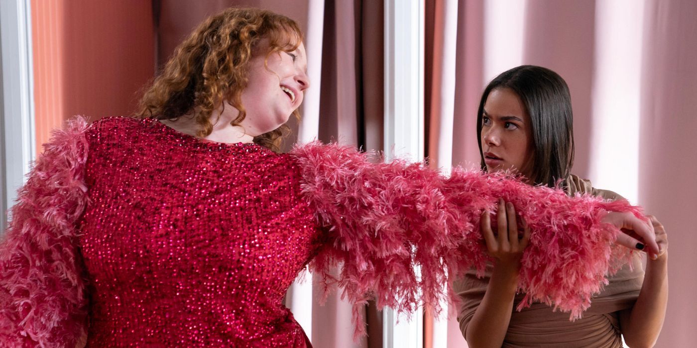 Julia Lester extends her arm dressed in a hot pink dress & Antonia Gentry holds her arm, looking shocked