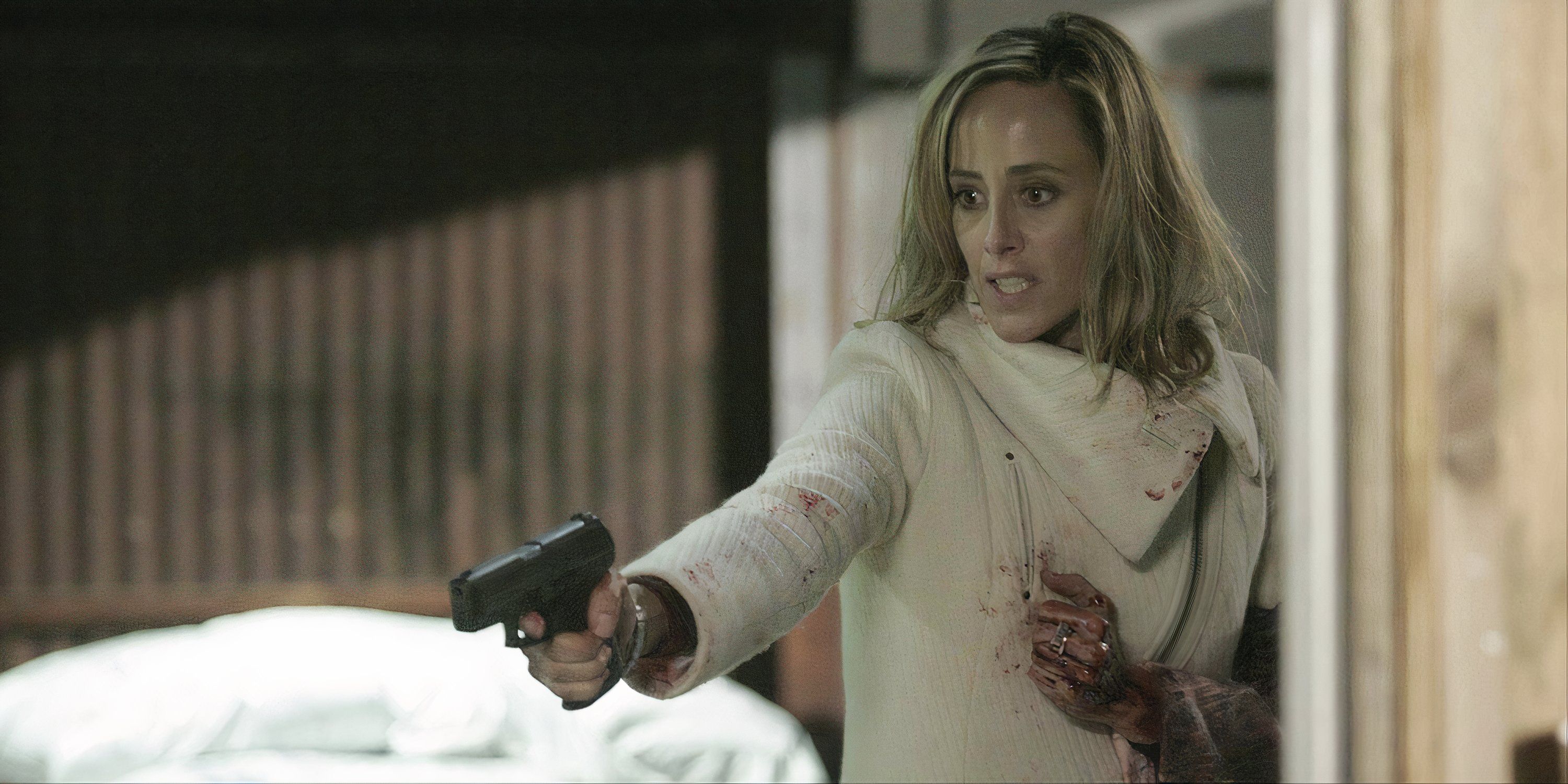 Leslie Hope pointing a gun with blood on her hand in 24