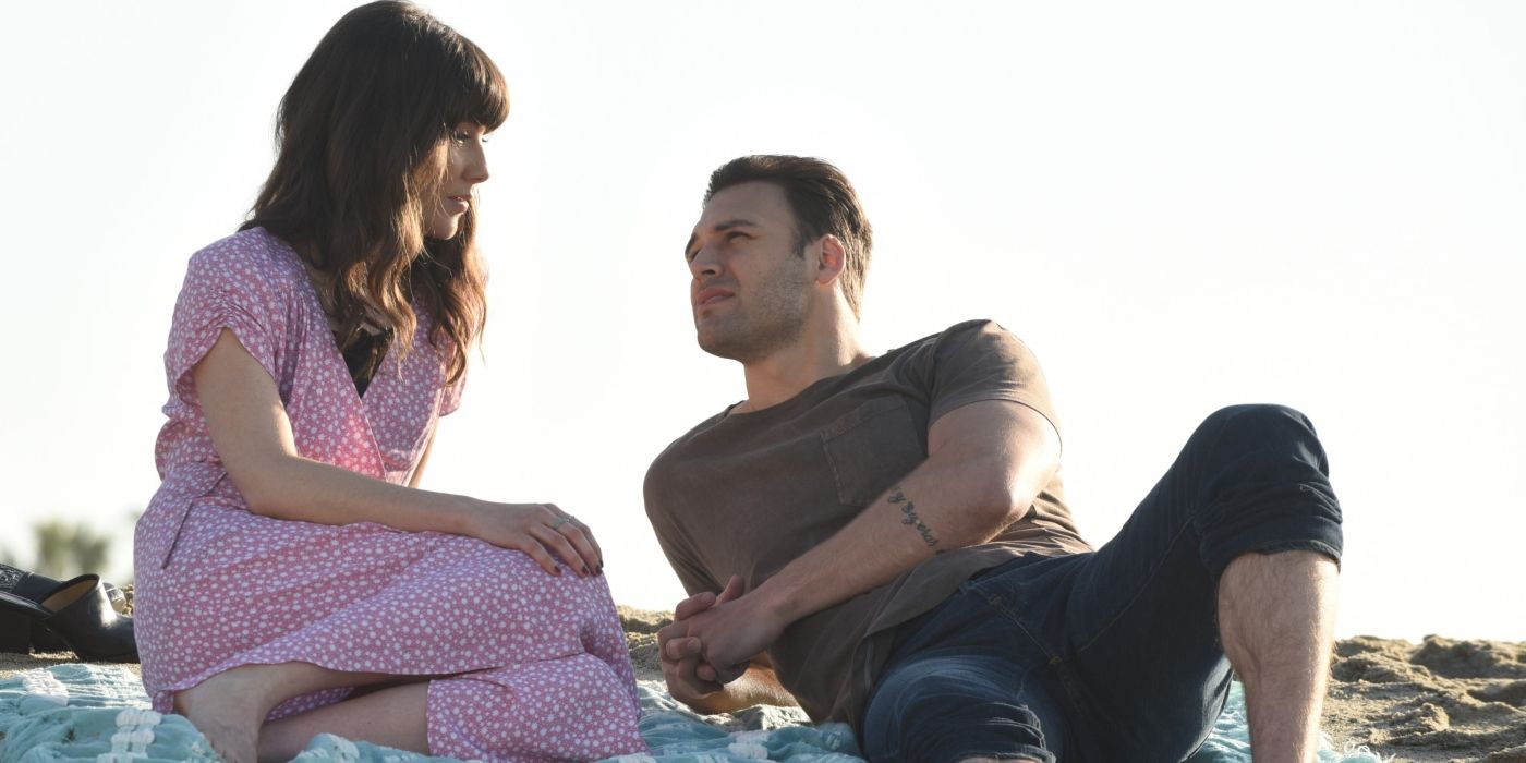 Shannon and Eddie lay on a blanket on the sand in a scene from '9-1-1.'