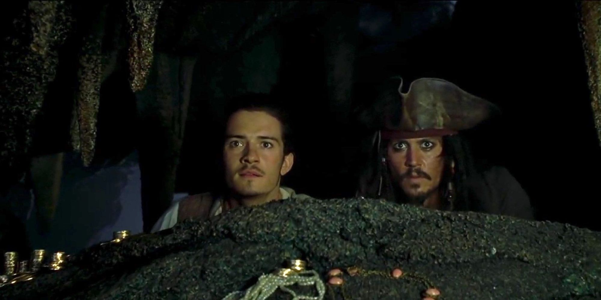 Will and Jack hide behind a rock in Pirates of the Caribbean The Curse of the Black Pearl