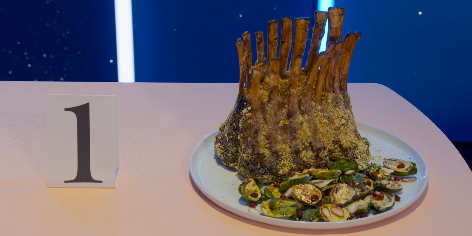 a crown of ribs made of cake sits next to a number 1 on a fancy table on Netflix's Is It Cake