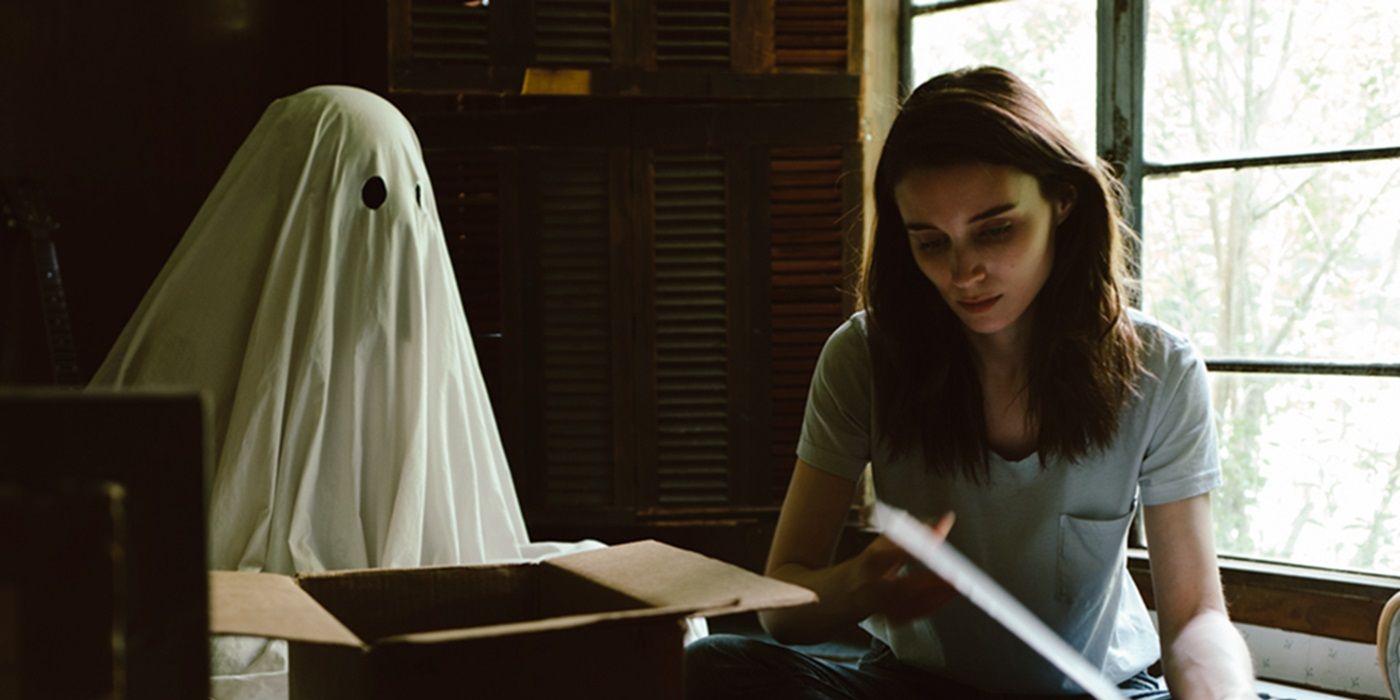 Casey Affleck as Ghost C sitting beside Rooney Mara as M in A Ghost Story