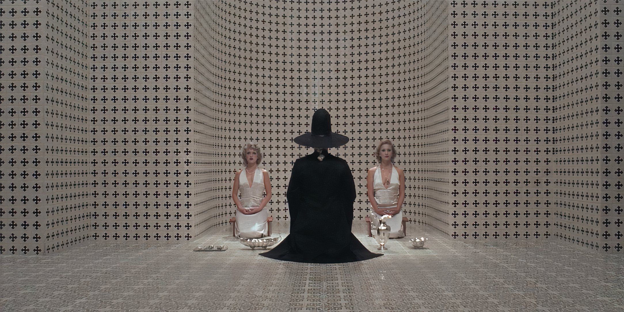 A witch and two women in a white room with black patterns in 'The Holy Mountain'