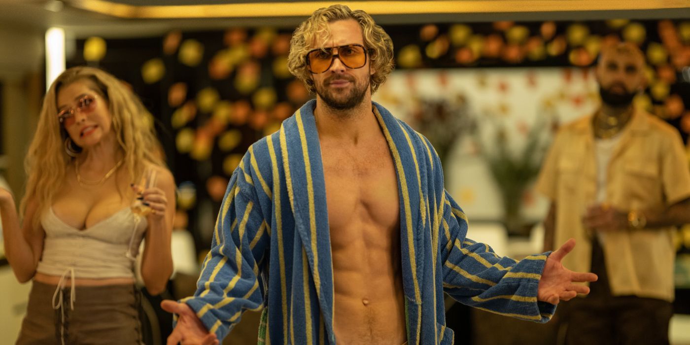 Aaron Taylor-Johnson in a blue and yellow striped bathrope wearing sunglasses as Tom Ryder.