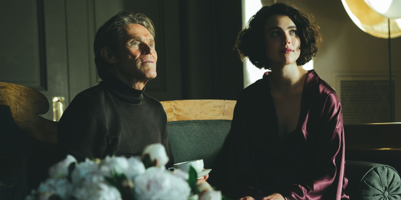 Willem Dafoe and Margaret Qualley sitting on a green velvet couch in Kinds of Kindness.