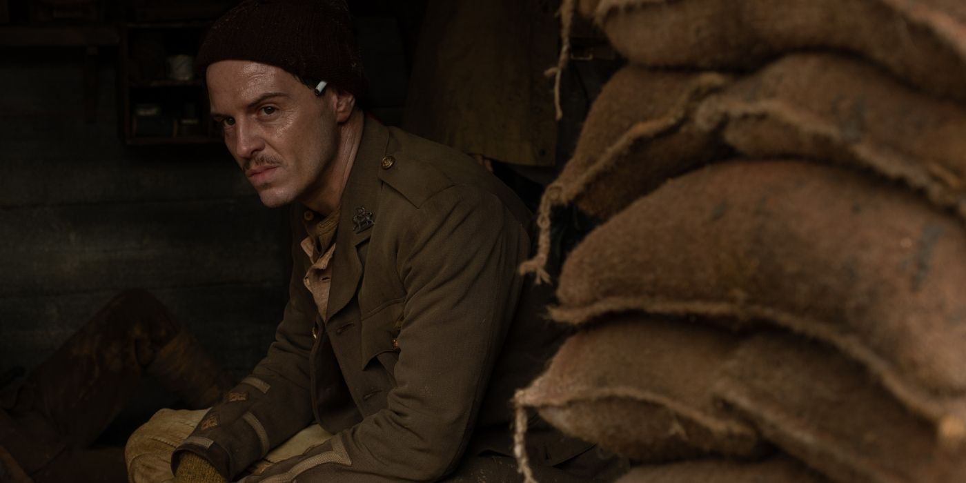 Lieutenant Leslie sits hunched by a pile of sandbags as he waits in the trenches in '1917' (2019).