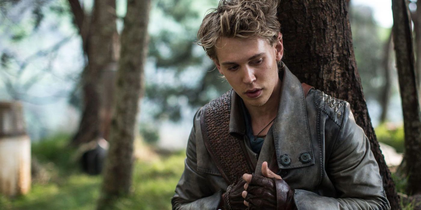 Austin Butler clasping his hands sitting against a tree in the Shannara Chronicles