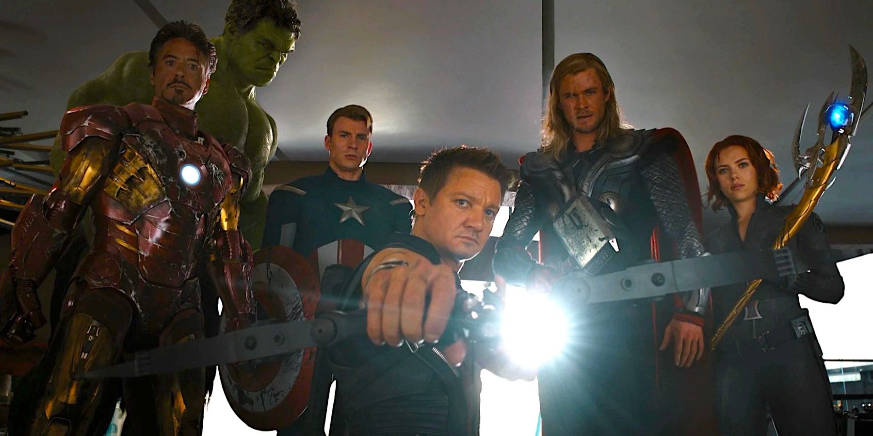 Iron Man (Robert Downey Jr.), Hulk (mark Ruffalo), Captain America (Chris Evans), Hawkeye (Jeremy Renner), Thor (Chris Hemsworth) and Black Widow (Scarlett Johansson), stand heroically in the wreckage of Stark Tower, staring down at the camera in The Avengers.
