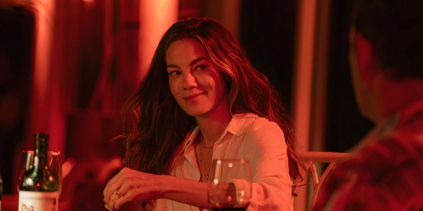 Michelle Monaghan is colored in red lighting and smiles at Vince Vaughn in ‘Bad Monkey’