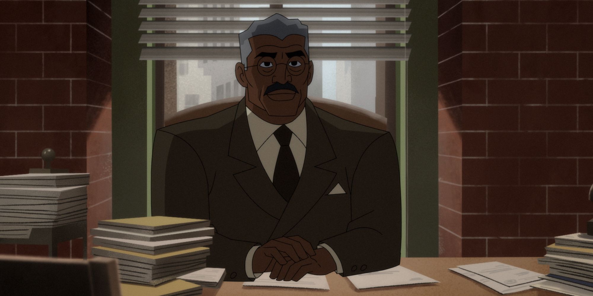 Jim Gordon sentado en su escritorio en Batman: Caped Crusader